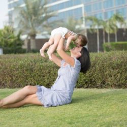 Mother holding young child over her head