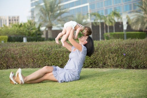 Mother holding young child over her head